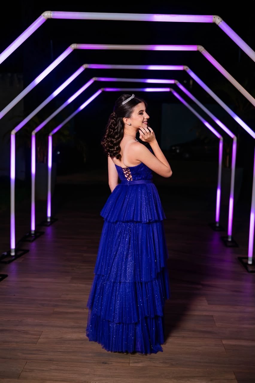 Debutante de vestido azul sob túnel de luzes