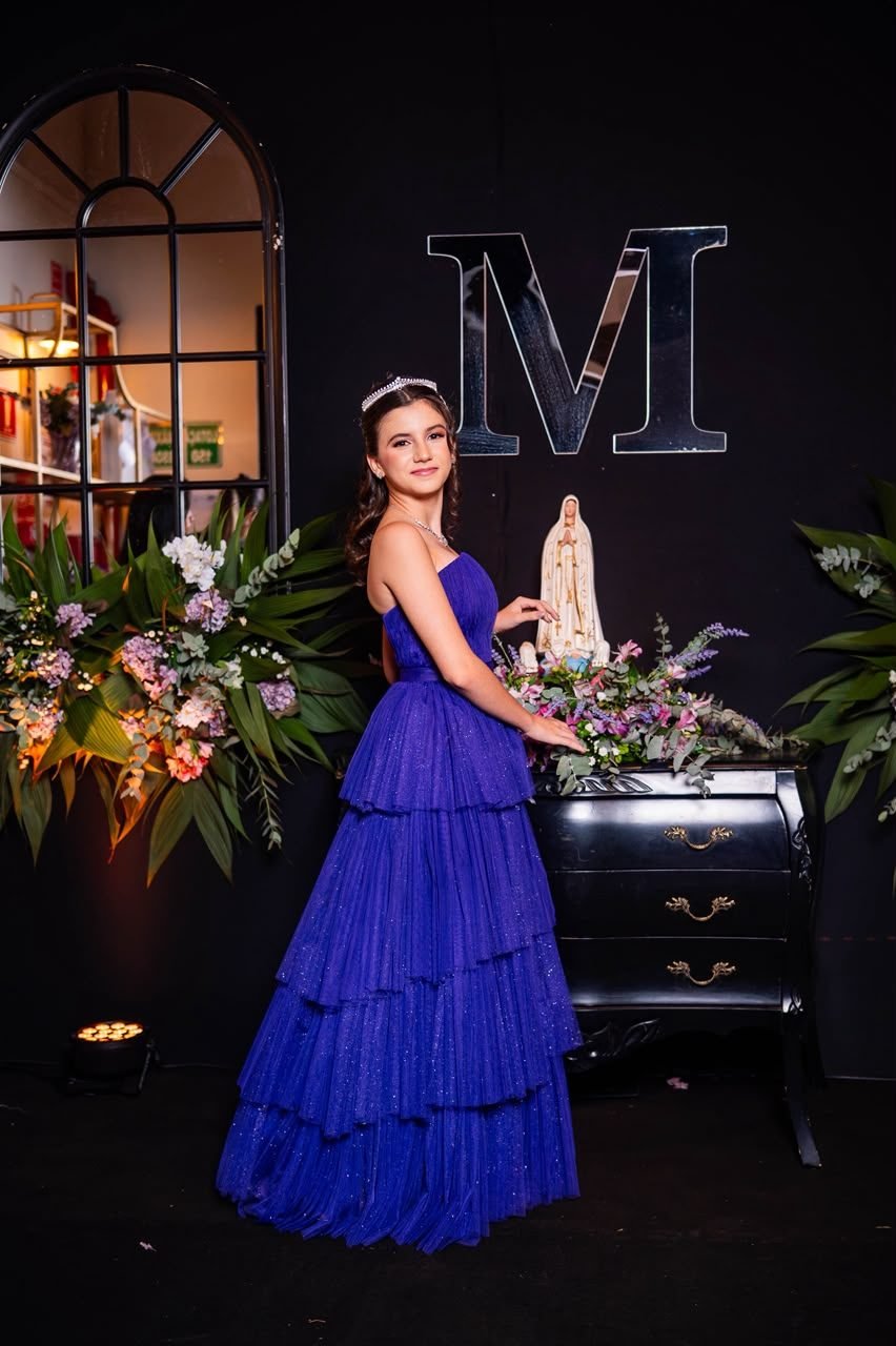 Debutante de vestido azul em cenário com flores
